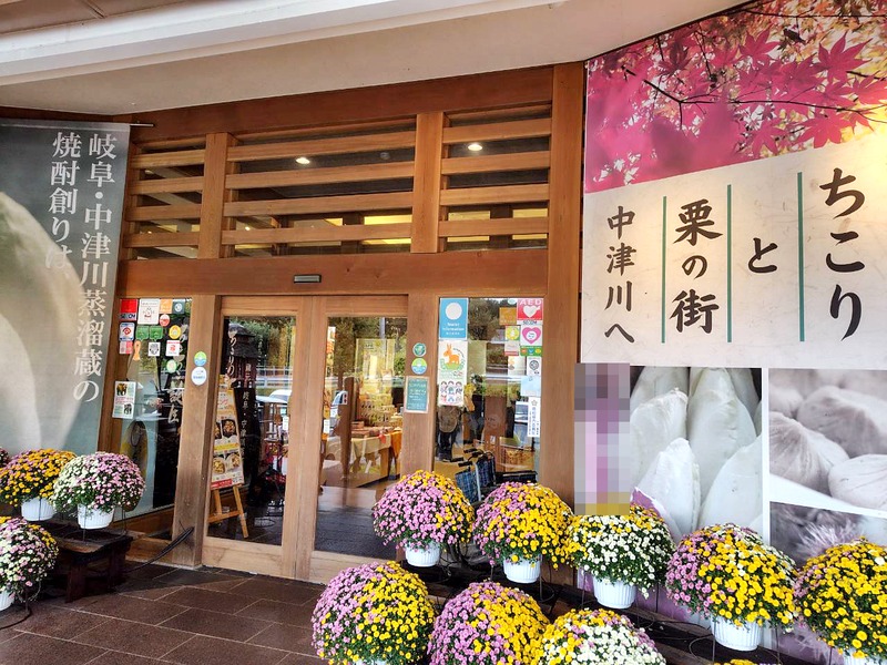 木の格子の扉と「ちこりと栗の街 中津川へ」の看板