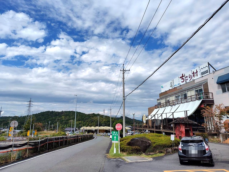 屋根に「ちこり村」の看板がある建物と道路