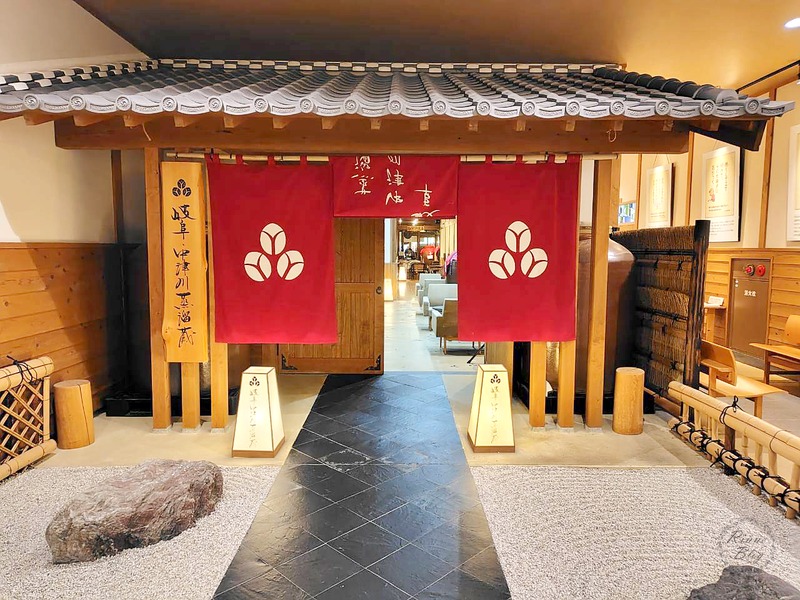 瓦屋根と赤いのれんの蒸溜蔵の門