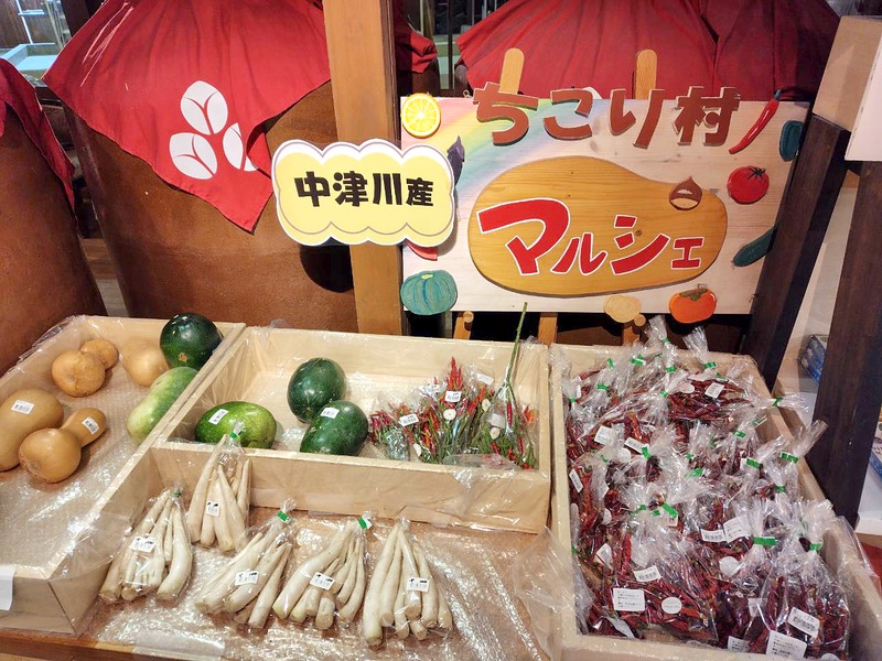 「中津川産」の札と「ちこり村 マルシェ」の看板、地元の野菜