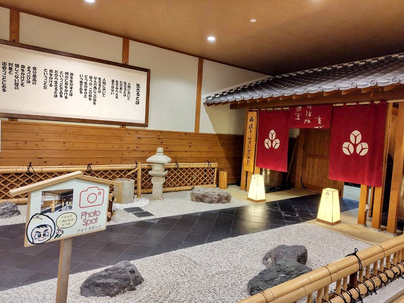 砂利の庭の前に立つフォトスポットの札