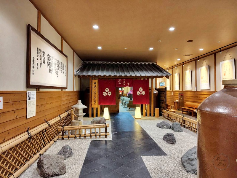 瓦屋根の門と白い砂利の庭が続く、蒸溜蔵の入口の通路