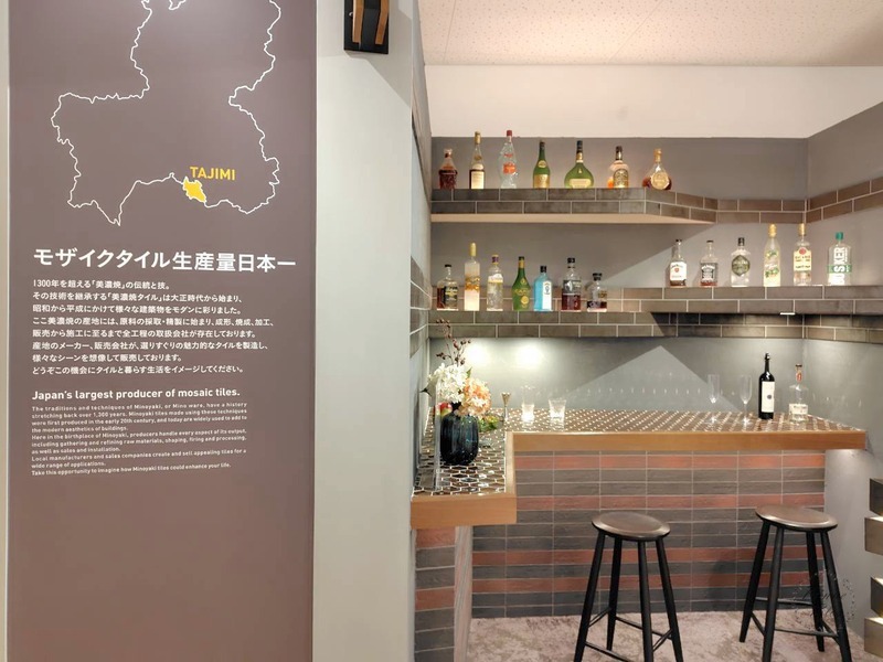 「モザイクタイル生産量日本一」のパネルとタイル張りのバーカウンター