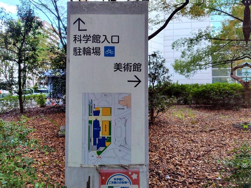「科学館入口」と「駐輪場」の方向を示す案内板