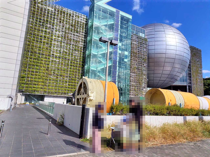 緑の壁と銀色の球体が見える科学館の外観