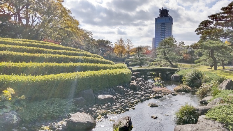 築山と石橋の向こうに見える静岡市街のビル